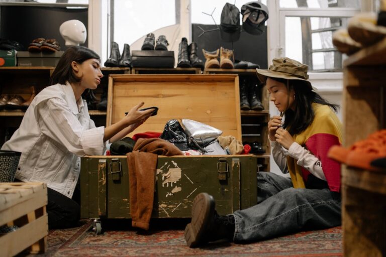 Two women exploring vintage fashion in a cozy thrift store, surrounded by clothes and shoes.