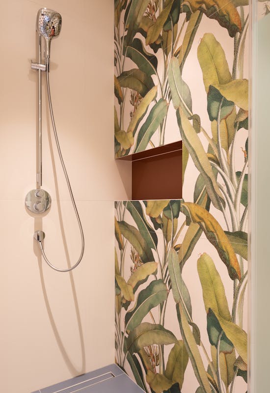 Contemporary bathroom featuring a stylish botanical-themed accent wall with a sleek shower setup.